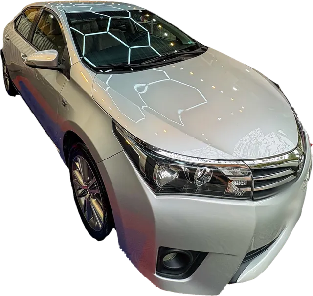 Corolla prata polido pela GL, com a colmeia de LED refletida no capô.